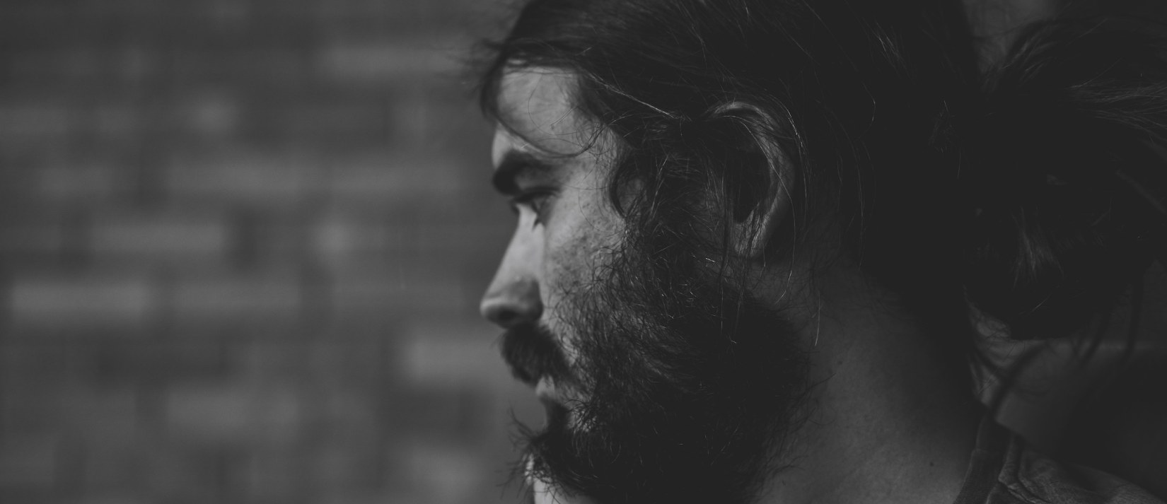 Black and white profile portrait of a bearded man looking into the distance